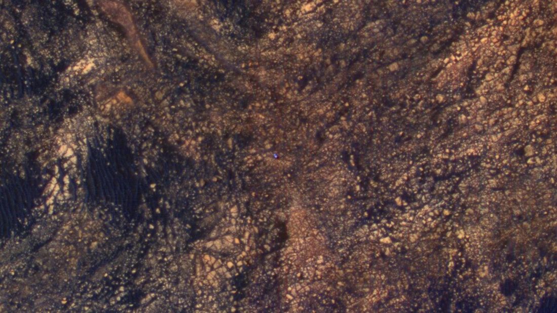 The bright blue speck in the middle of this image is NASA's Curiosity Mars rover. The image was taken from another NASA spacecraft, Mars Reconnaissance Orbiter, which is in orbit above the planet, on June 6, 2017.