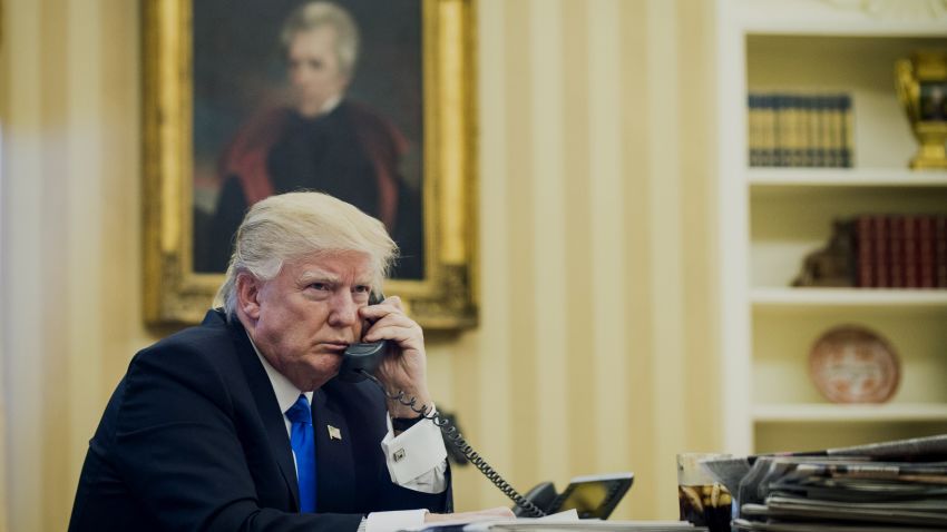 U.S. President Donald Trump speaks on the phone with Malcolm Turnbull, Australia's prime minister, during the first official phone talks in the Oval Office of the White House in Washington, D.C., U.S., on Saturday, Jan. 28, 2017. Turnbull is confident the new U.S. administration will uphold an agreement to resettle asylum seekers held on Pacific island camps. Photographer: Pete Marovich/Pool via Bloomberg
