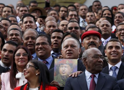 Diosdado Cabello, a member of Venezuela's National Constituent Assembly, holds an image of Venezuela's late President Hugo Chavez as delegates gather for a group photo following their swearing-in ceremony on Friday, August 4.
