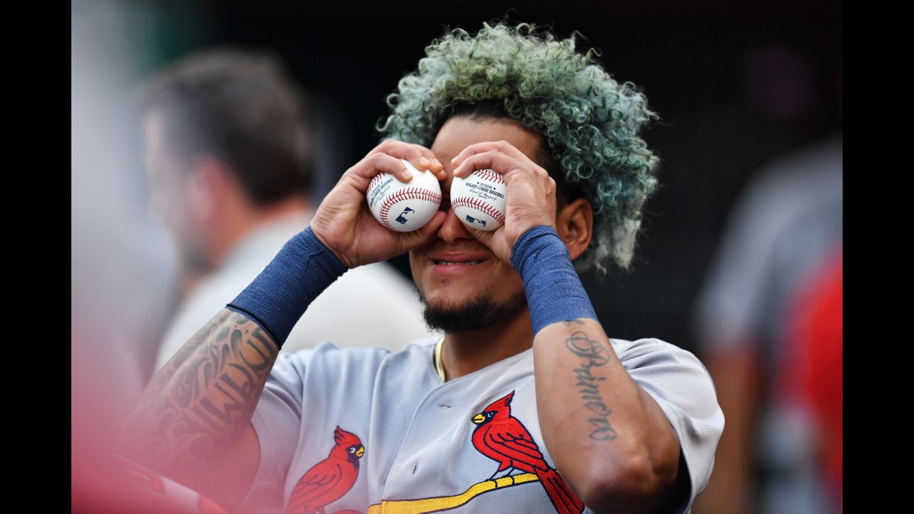 St. Louis pitcher Carlos Martinez turns a pair of baseballs into binoculars as he fools around in the dugout on Saturday, August 5.