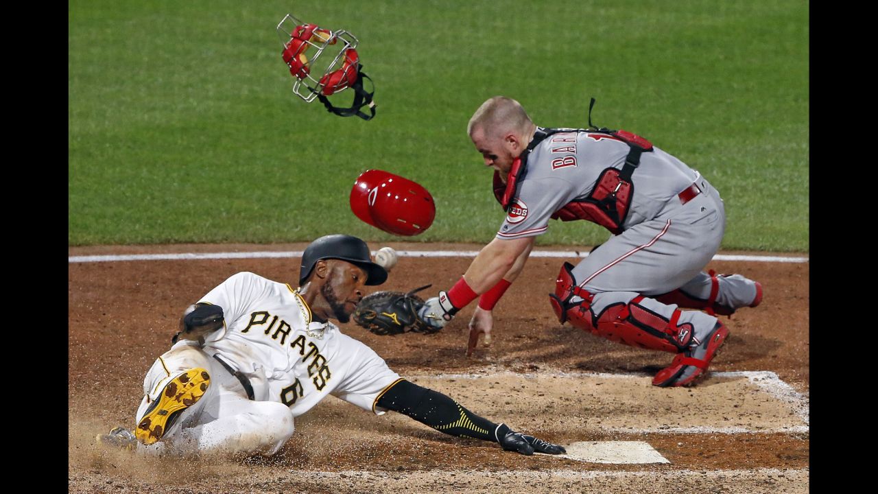 Cincinnati catcher Tucker Barnhart drops the ball as Pittsburgh's Starling Marte slides into home on Wednesday, August 2.