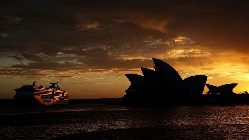 SYDNEY, AUSTRALIA - DECEMBER 16:  A cruise ship travels alongside the Sydney Opera House at sunrise on December 16, 2014 in Sydney, Australia.  The siege in Sydney's Lindt Cafe in Martin Place is over after 16 hours. Police raided the cafe just after 2am AEDT on Tuesday morning. Three people have been confirmed killed, two hostages and the gunman. (Photo by Mark Metcalfe/Getty Images)