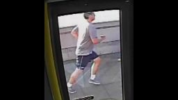 Still taken from CCTV footage released by Metropolitan Police of Police a jogger who appeared to push a woman into the path of an oncoming bus in Putney.
At about 07:40hrs on Friday, 5 May the 33-year-old victim was walking across Putney Bridge on the east side heading towards Putney Bridge Tube Station when a male jogger knocked her over into the road and into the path of an oncoming bus, which narrowly missed hitting her.