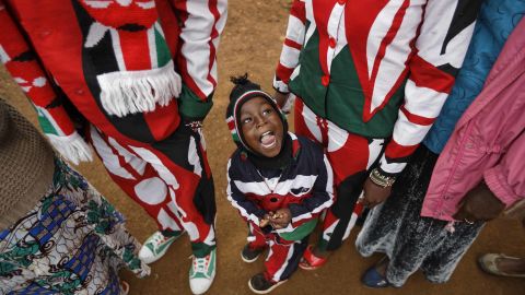 Joseph Njoroge Kimani, 3, stands with his parents as they wait to vote in Gatundu.
