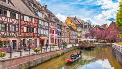 Beautiful view of the historic town of Colmar, also known as Little Venice, with tourists taking a boat ride along traditional colorful houses on idyllic river Lauch in summer, Colmar, Alsace, France; Shutterstock ID 568268620