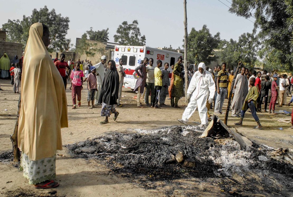 A woman stands at the site where four female suicide bombers blew themselves up near a bus station in Maiduguri on March 15, 2017, killing two people.