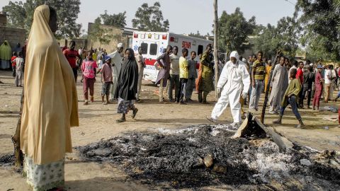 A woman stands at the site where four female suicide bombers blew themselves up near a bus station in Maiduguri on March 15, 2017, killing two people.