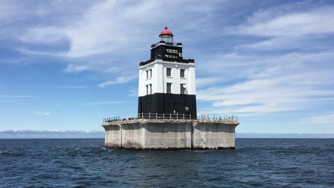 The Poe Reef lighthouse in Cheboygan, Michigan, features a 71-foot-tall square tower on a concrete crib. It is one of six out-of-commission lighthouses that are being auctioned by the US government at an asking price of around $15,000 each.