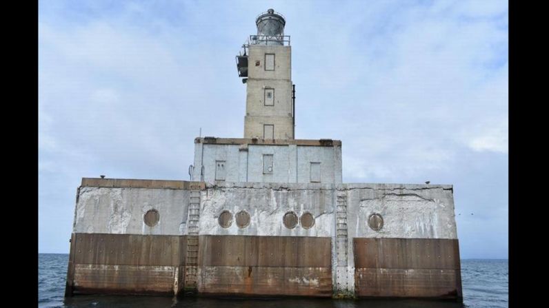 The Lansing Shoals Lighthouse, built in 1928, stands 69 feet tall in waters off Naubinway, Michigan. It has two floors and a basement. The listing warns that there's asbestos and lead-based paint present.