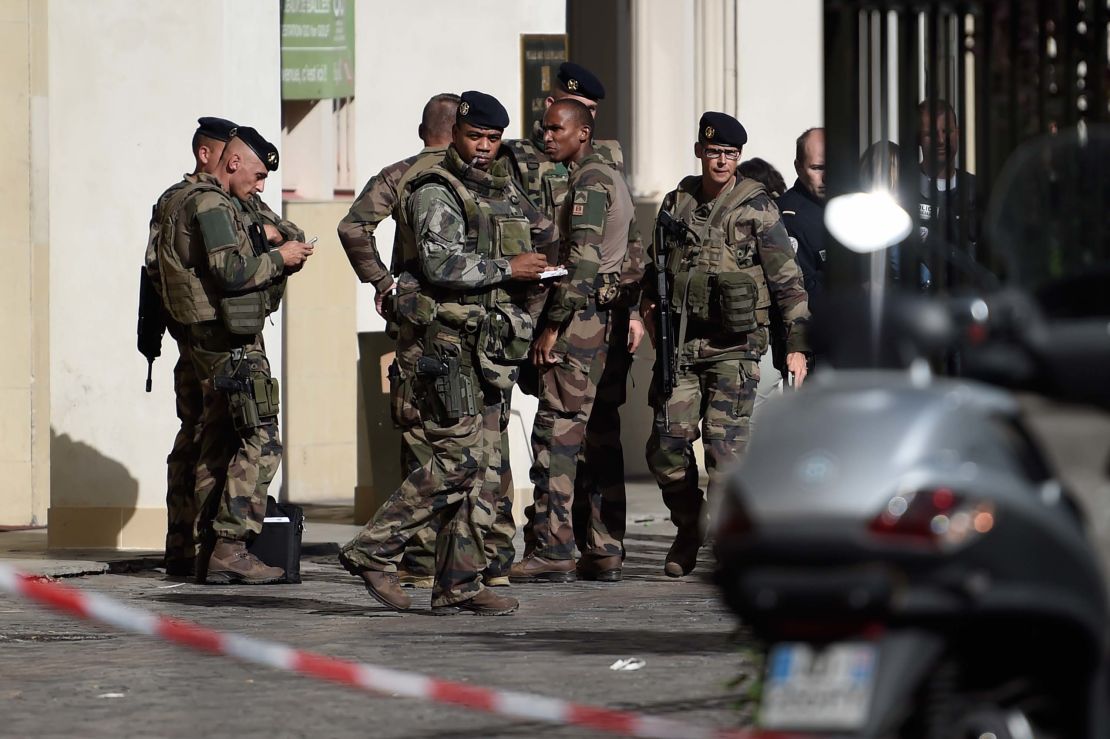 French soldiers gather at the site where a car slammed into soldiers on patrol in Levallois-Perret, outside Paris, on August 9, 2017.
