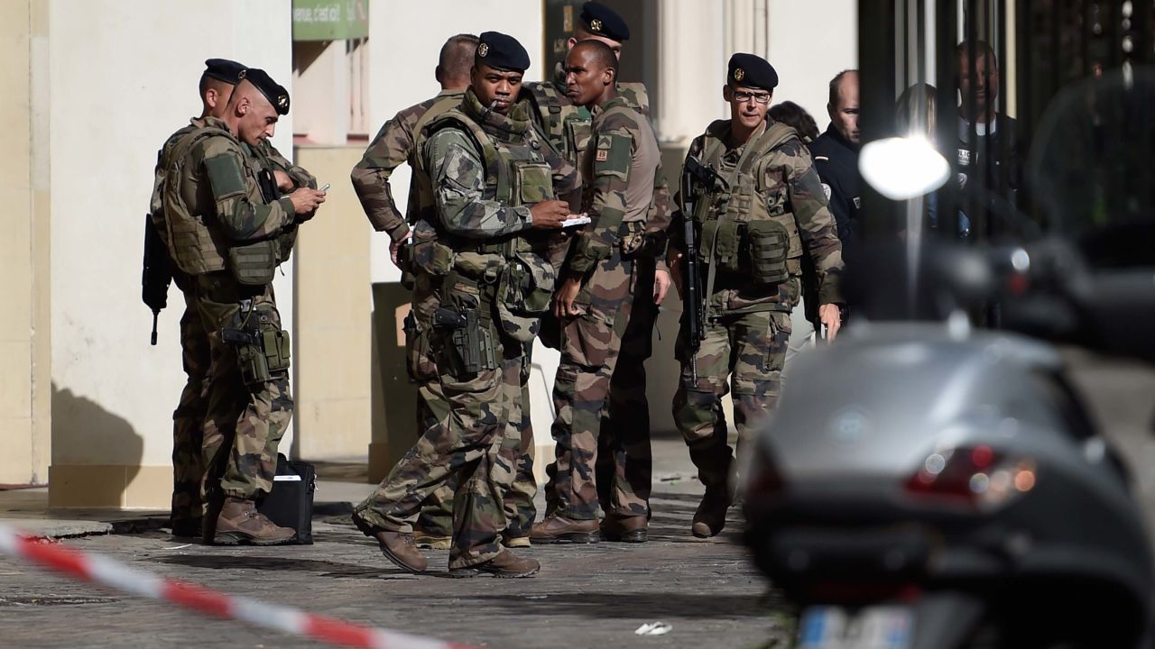 French soldiers gather at the site where a car slammed into soldiers on patrol in Levallois-Perret, outside Paris, on August 9, 2017.