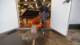 Dwayne Boudreaux, Jr., owner of the Circle Food Store, dumps out dirty water that was vacuumed up from the store, in the aftermath of flooding this past weekend, in New Orleans, Monday, Aug. 7, 2017. (AP Photo/Gerald Herbert)