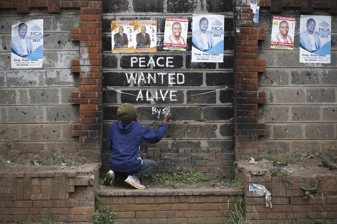 Street artist Solomon Muyundo, also known as Solo7, paints a message of peace on the wall in Kibera slum, one of Odinga's strongholds in the capital Nairobi on Wednesday.