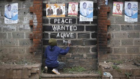 Street artist Solomon Muyundo, also known as Solo7, paints a message of peace on the wall in Kibera slum, one of Odinga's strongholds in the capital Nairobi on Wednesday.