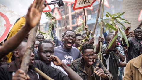Supporters of opposition presidential candidate Raila Odinga shout and brandish sticks during a protest in the Mathare slums of Nairobi on Wednesday.
