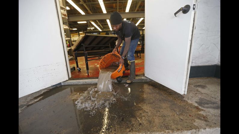 Dwayne Boudreaux Jr., owner of the Circle Food Store in New Orleans, dumps out dirty floodwater on Monday, August 7. A historic rainstorm<a href="http://www.cnn.com/2017/08/09/us/new-orleans-flood-fallout/index.html" target="_blank"> flooded homes and exposed critical weaknesses</a> in the city's drainage pumping operation.