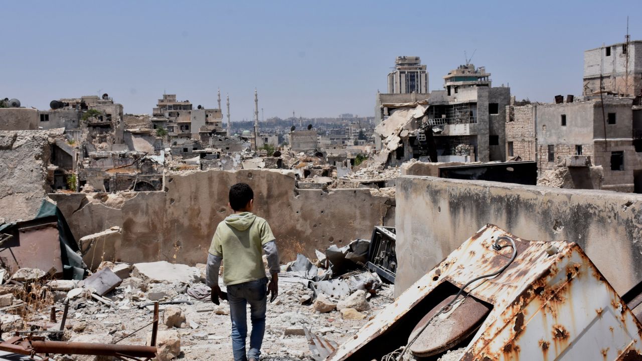 TOPSHOT - A Syrian boy walks amid the rubble of destroyed buildings on July 22, 2017, in the northern city of Aleppo, which was recaptured by government forces in December 2016. / AFP PHOTO / George OURFALIAN        (Photo credit should read GEORGE OURFALIAN/AFP/Getty Images)