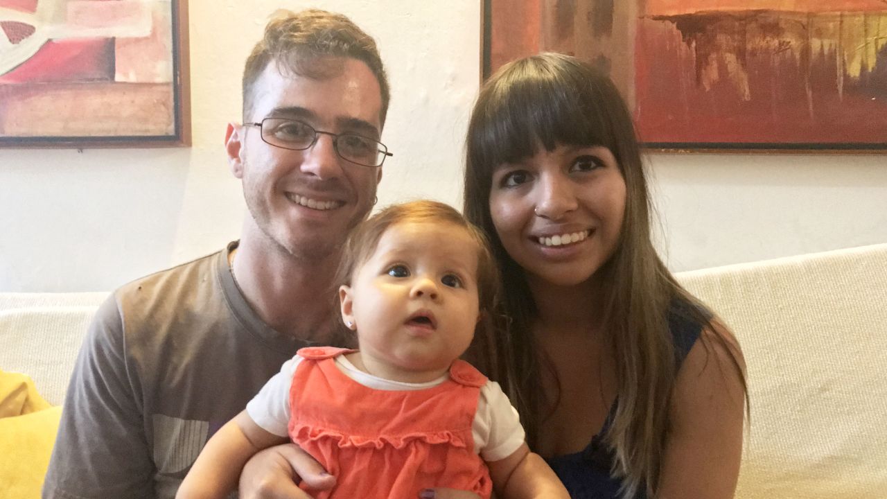  Carolina Wong and Jorge Salas sit with their daughter, Akira, before they leave Venezuela for Peru. 