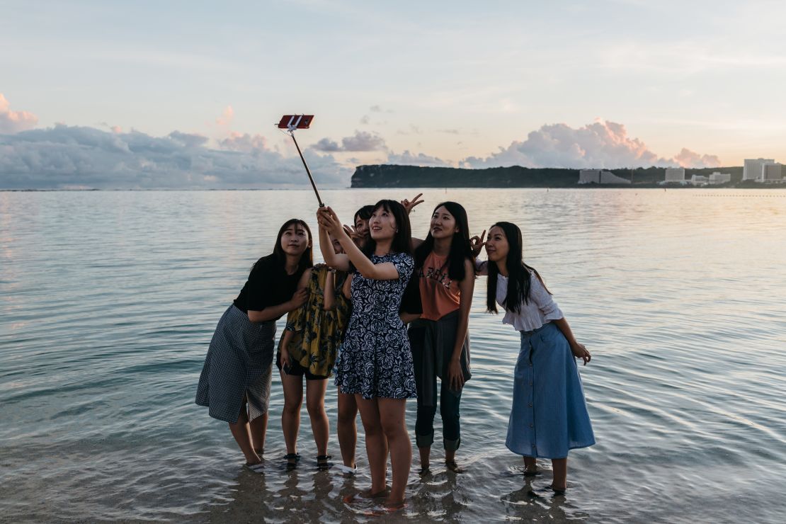 Duhyun Na, right, and her friends take selfies at Ypao Beach Park.