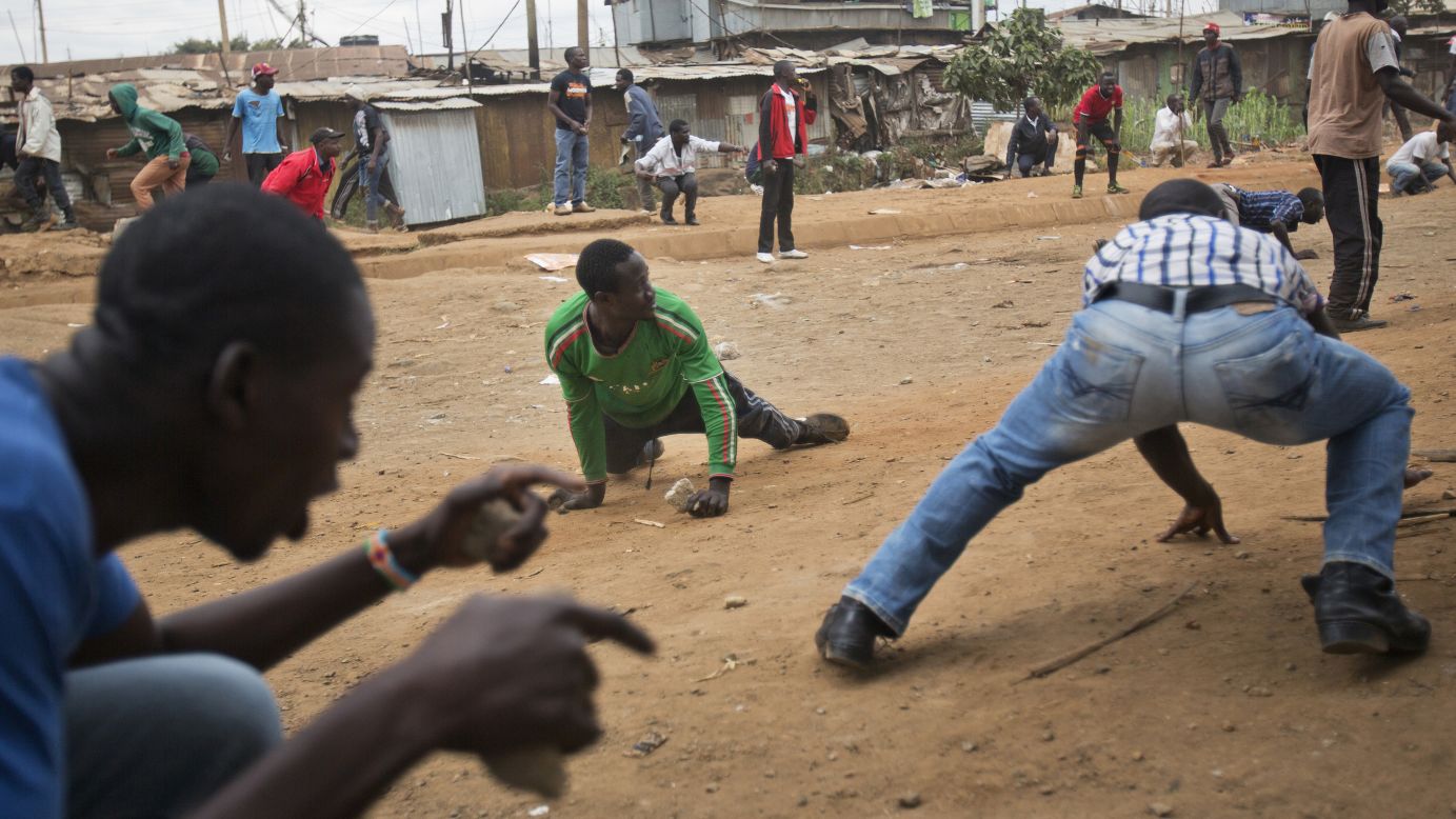 Odinga supporters duck for cover as they face off against Kenyan security forces in the Kibera slum of Nairobi.