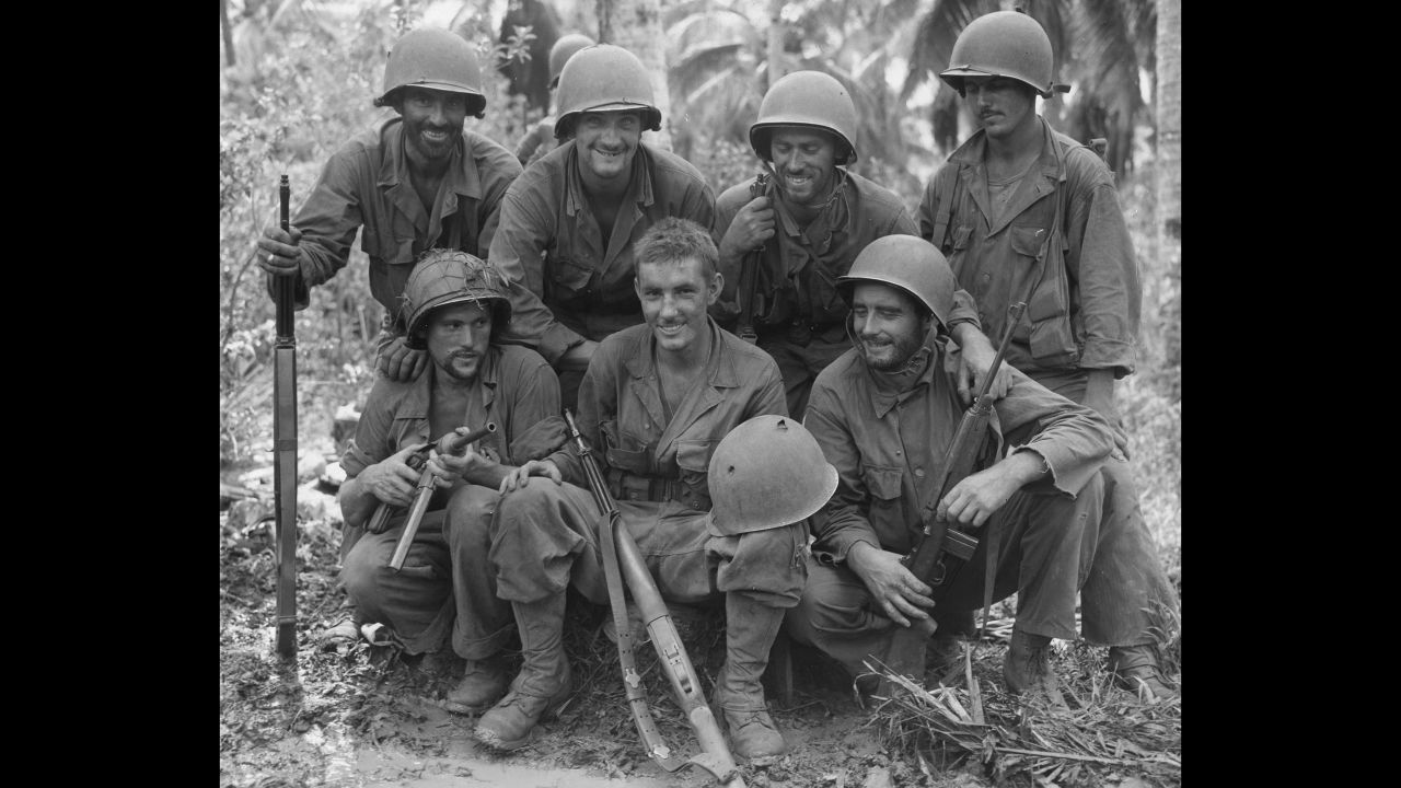 Pvt. William N. Wade, front and center, displays his helmet, punctured by a Japanese sniper near Barrigada, Guam, to his buddies, members of the Army's 77th Infantry Division, Aug. 23, 1944. From left, front row: Cpl. Harold Boyes of Ohio; Pvt. Wade; Pfc. William Kusch, Bayside, New York. Second row: Cpl. Joseph A. Hargraves of Massachusetts; Pfc. Willard Haus of Endicott, New York; Staff Sgt. Stephen Kelly of Brooklyn, New York; and Pvt. Joe Tremallo of Morristown, New Jersey.