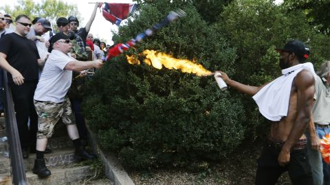 A counterprotester uses a lighted spray can against a white nationalist at the entrance to Emancipation Park.