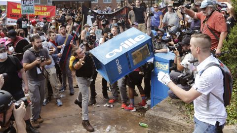 A counterprotester throws a newspaper box at a right-wing rally member at the entrance to Emancipation Park.