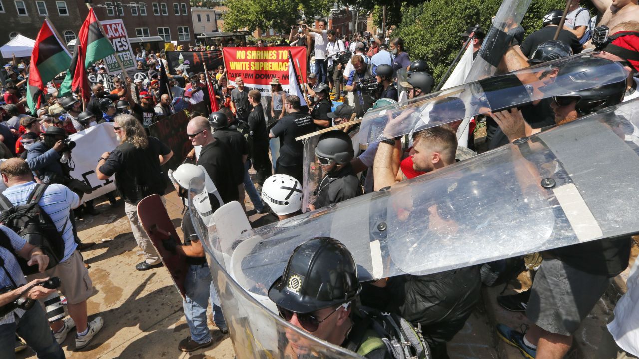 White nationalist demonstrators use shields as they clash with counter demonstrators at the entrance to Lee Park in Charlottesville, Virginia, Saturday, August 12, 2017.   Hundreds of people chanted, threw punches, hurled water bottles and unleashed chemical sprays on each other Saturday after violence erupted at a white nationalist rally in Virginia. At least one person was arrested.