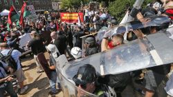 White nationalist demonstrators use shields as they clash with counter demonstrators at the entrance to Lee Park in Charlottesville, Virginia, Saturday, August 12, 2017.   Hundreds of people chanted, threw punches, hurled water bottles and unleashed chemical sprays on each other Saturday after violence erupted at a white nationalist rally in Virginia. At least one person was arrested.