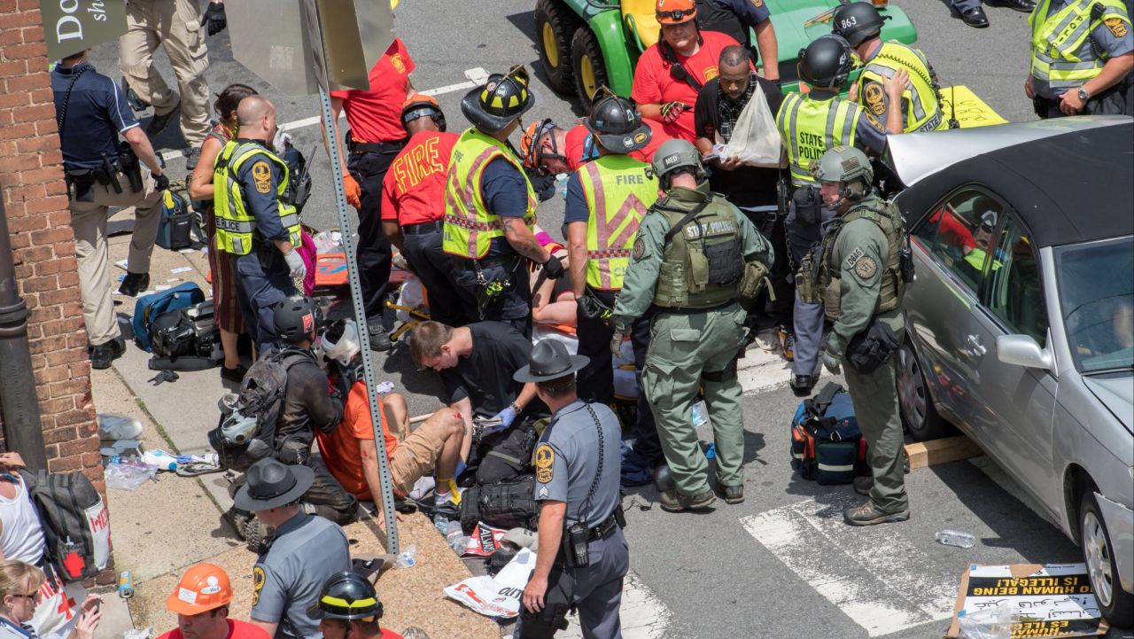 People receive first-aid after a car accident ran into a crowd of protesters in Charlottesville, Virginia on August 12, 2017.