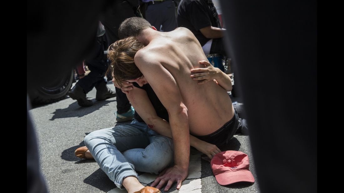 A man embraces an injured woman after a car rammed into the crowd. 