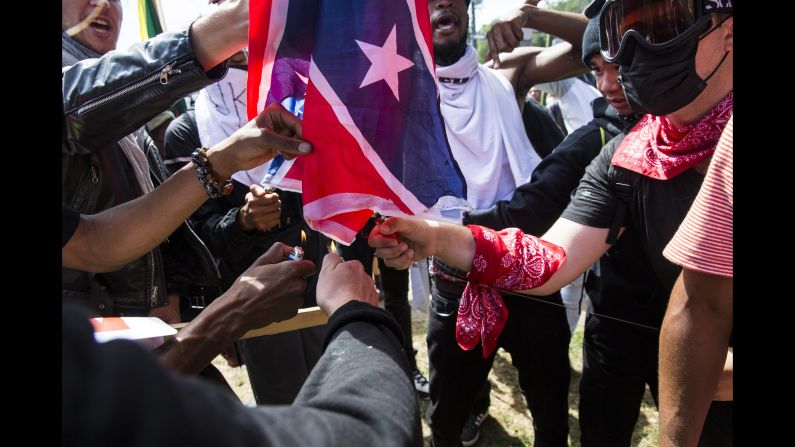Counterprotesters try to burn a Confederate battle flag taken from white nationalist protesters.
