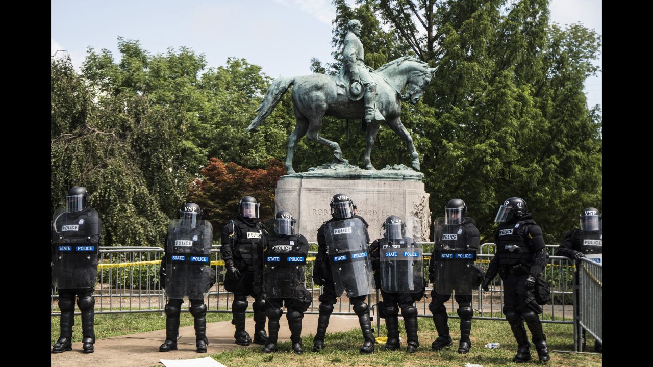 Riot police form a line of defense in front of the statue of Confederate Gen. Robert E. Lee in Emancipation Park, recently renamed from Lee Park.