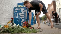A man places flowers at a makeshift memorial for the victims of Saturday's attack, in which a car plowed into a crowd of demonstrators opposing a nearby white nationalist rally in Charlottesville, Virginia.