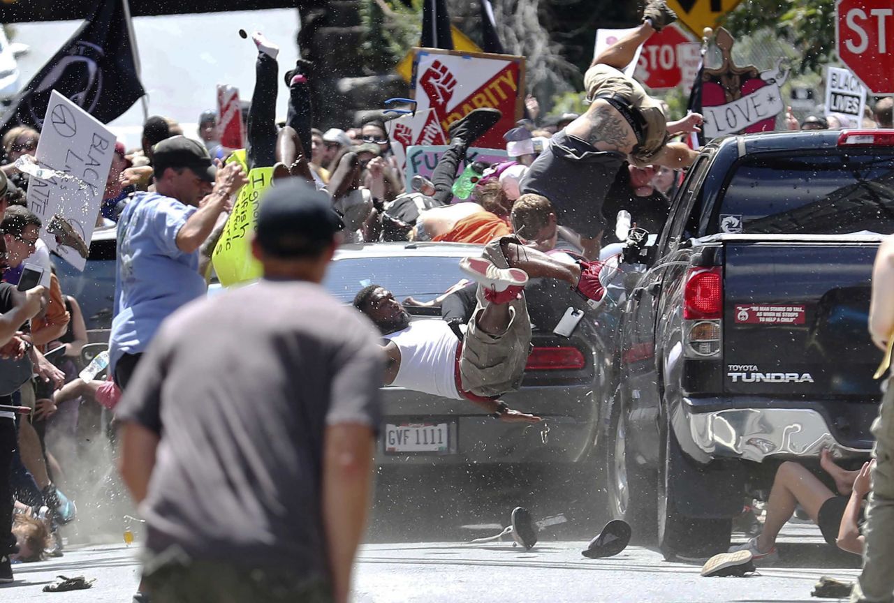 People fly into the air as a vehicle drives into a group of people demonstrating against a white nationalist rally after police cleared Emancipation Park in Charlottesville, Virginia, on Saturday, August 12. 