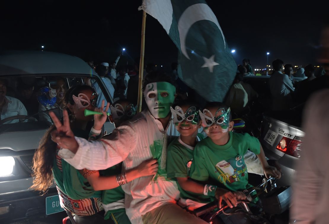 Youths wear masks as they march on a street in Islamabad on the night of August 13, 2017, to mark the country's Independence Day. 
