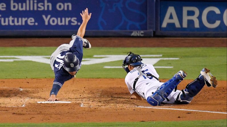 San Diego's Hunter Renfroe, left, reaches for the base after being tagged out by Los Angeles Dodgers catcher Austin Barnes on Friday, August 11.