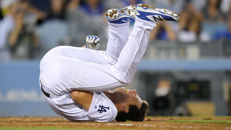 Rich Hill, a pitcher for the Los Angeles Dodgers, writhes on the ground after getting hit in the throat with a fastball on Friday, August 11. He stayed in the game.