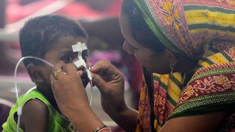 An Indian woman looks after her child at the encephalitis ward on August 14.