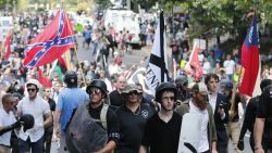 White nationalist demonstrators walk through town after their rally was declared illegal near Lee Park in Charlottesville, Va., Saturday, Aug. 12, 2017. (AP Photo/Steve Helber)