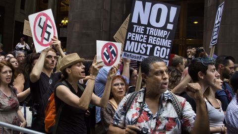 Protesters shout slogans in front of Trump Tower ahead President Donald Trump's visit Monday.