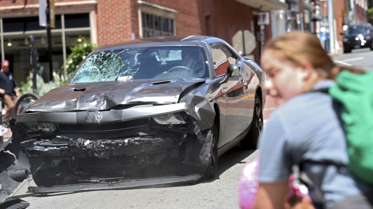 The damaged car sped away in reverse after striking the demonstrators. 