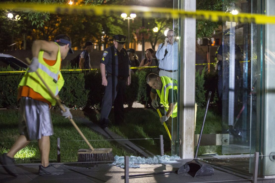 Workers clean up broken glass at the New England Holocaust Memorial.