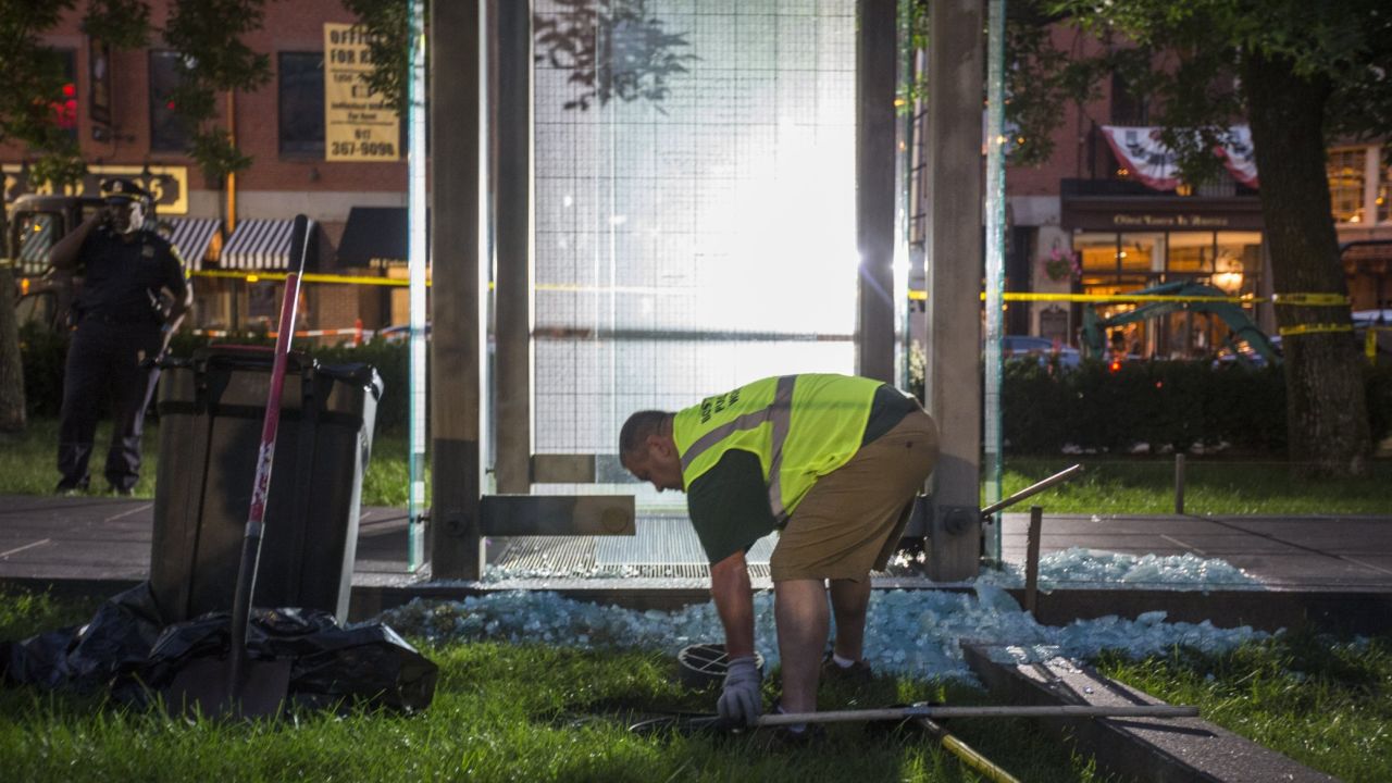 A worker cleans up broken glass at the New England Holocaust Memorial that was vandalized Monday.