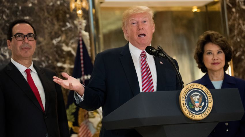 Flanked by Secretary of Treasury Steve Mnuchin and Transportation Secretary Elaine Chao, US President Donald Trump delivers remarks following a meeting on infrastructure at Trump Tower, August 15, 2017 in New York City. He fielded questions from reporters about his comments on the events in Charlottesville, Virginia and white supremacists.