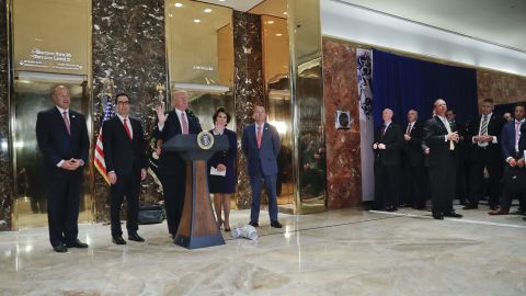 President Donald Trump speaks to the media in the lobby of Trump Tower. With Trump are from left, National Economic Council Director Gary Cohn, Treasury Secretary Steven Mnuchin, Transportation Secretary Elaine Chao and OMB Director Mick Mulvaney.
