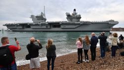 People line the shore to watch as tug boats manoeuvre the 65,000-tonne British aircraft carrier HMS Queen Elizabeth into Portsmouth Harbour in Portsmouth, southern England on August 16, 2017, as it arrives at for the first time in her home port.
The 65,000-tonne HMS Queen Elizabeth is one of two carriers being built at a combined cost of £6.2 billion ($10.6 billion, 7.8 billion euros) to overhaul Britain's naval capabilities. The ship measures 280 metres (920 feet) long -- the equivalent of 28 London buses or nearly three times the length of Buckingham Palace -- and 56 metres from keel to masthead. / AFP PHOTO / Ben STANSALL        (Photo credit should read BEN STANSALL/AFP/Getty Images)