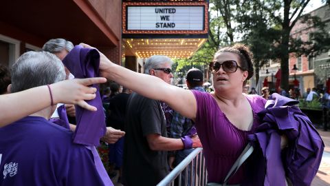 Anna Quillon hands out purple pieces of purple cloth outside Heather Heyer's memorial service on Wednesday. Purple was a favorite color of Heyer's.