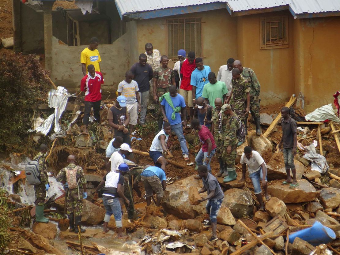 Volunteers search for bodies at the scene of the mudslide, which was caused by heavy rains.