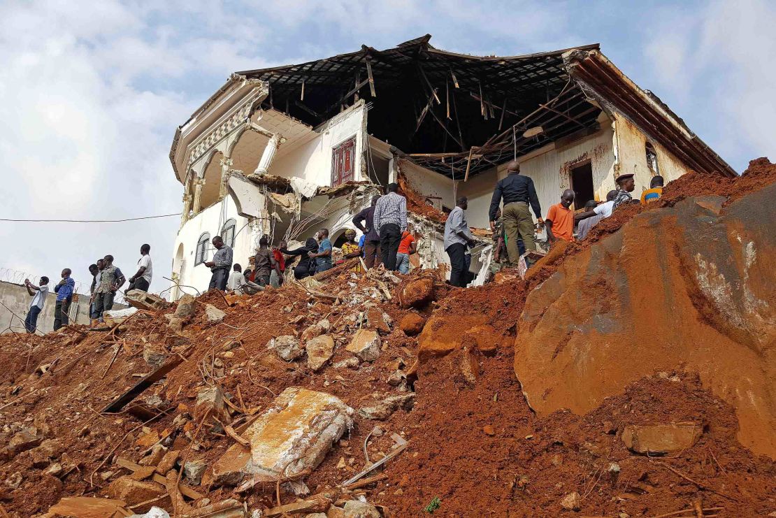 People inspect the damage at the mudslide site on Tuesday afternoon. Sierra Leone's President Ernest Bai Koroma has declared seven days of mourning across the country, with immediate effect.